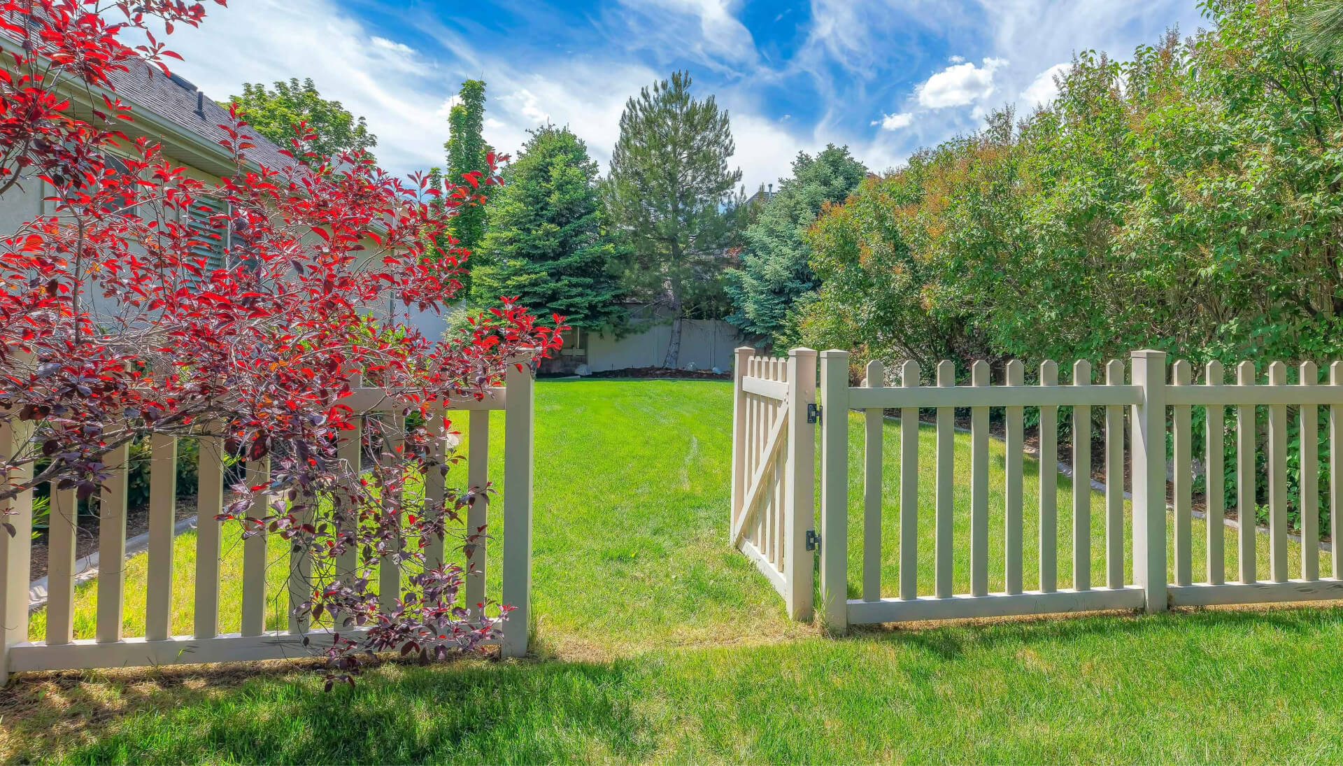 A functional fence gate providing access to a well-maintained backyard, surrounded by a wooden fence in Salem